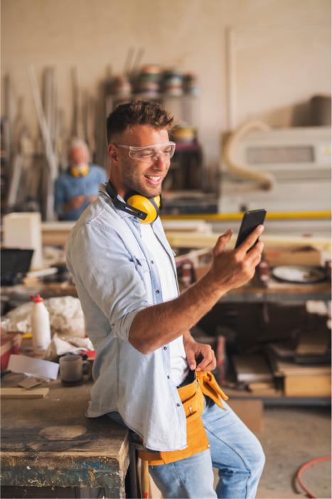 Worker in a workshop using his mobile