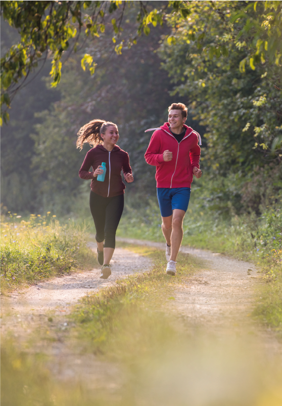 A man a women running through a forest